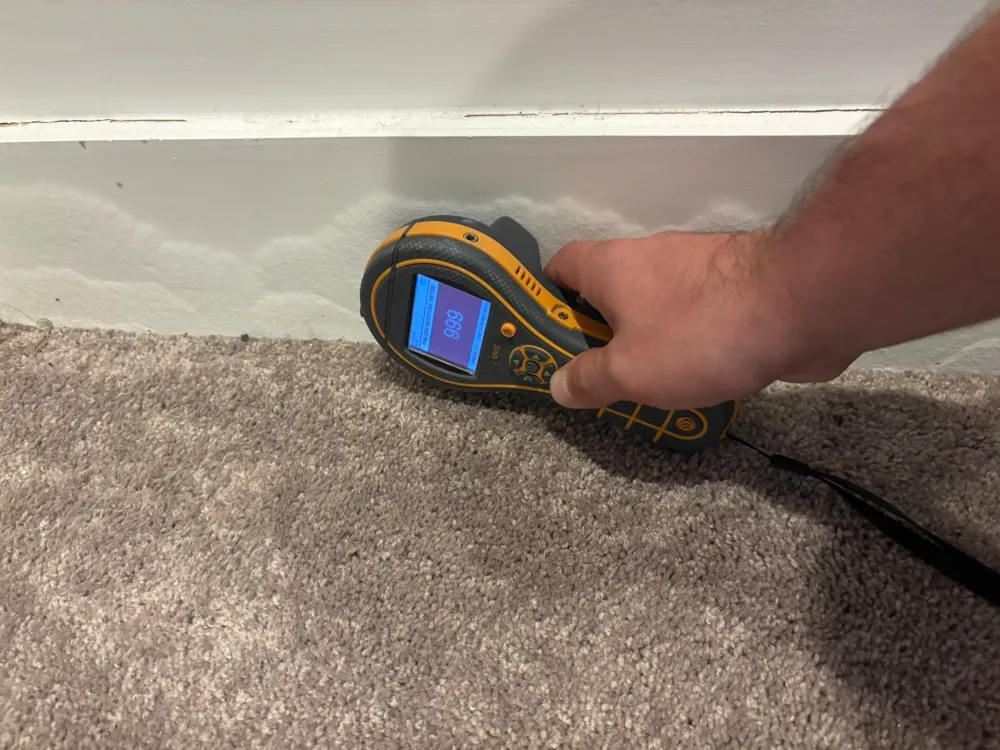 Moisture meter confirming a hidden water leak on a Nashville job site
